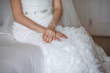 Engagement ring on bride's finger during wedding preparations.