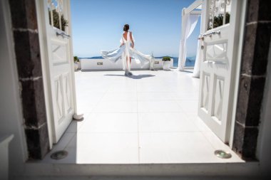 Bride in wedding dress posing on the balcony.