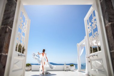 Bride in wedding dress posing on the balcony.