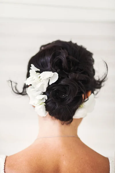 Bride in the morning during wedding preparations. Flowers in the bride\'s hair