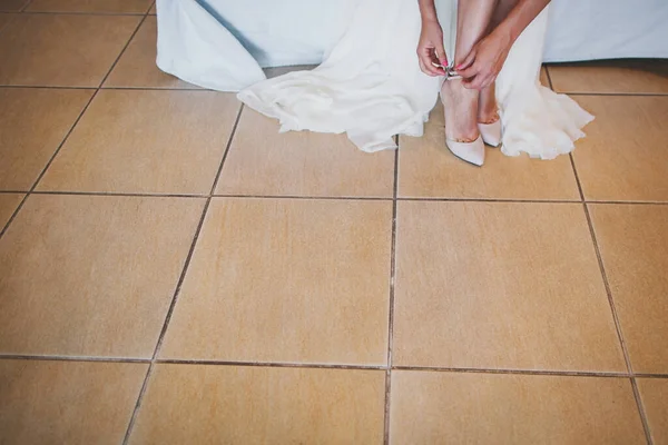 Bride in the morning during wedding preparations. Bride puts on shoes