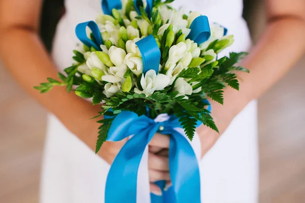 Bright wedding bouquet in hands of the bride.