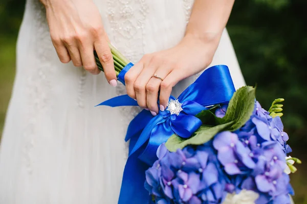 Bright wedding bouquet in hands of the bride.