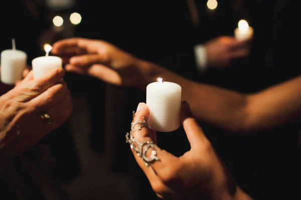 Candle in the hands of a guest at a wedding ceremony.