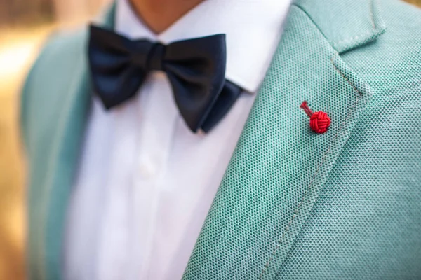 Elegant wedding boutonniere on the groom\'s suit.
