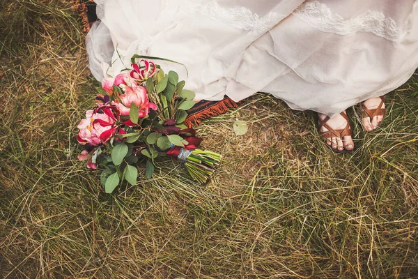 Bright wedding bouquet at the feet of the bride.