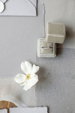 Wedding rings in a box and vintage invitations on the table.