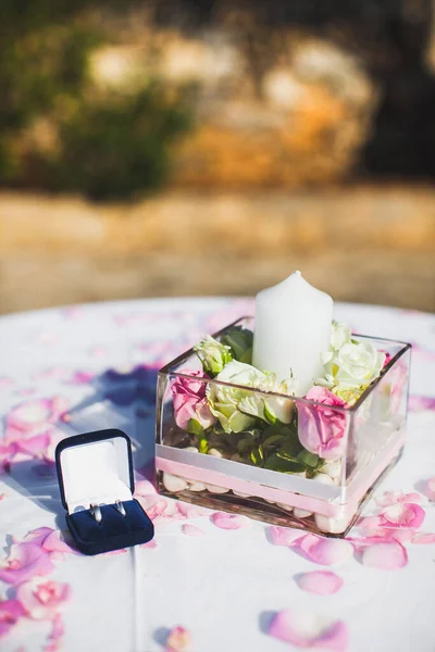 Wedding rings in a box and flowers on the table.