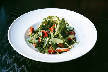 Yeşil salata, roka, mantar ve domates.