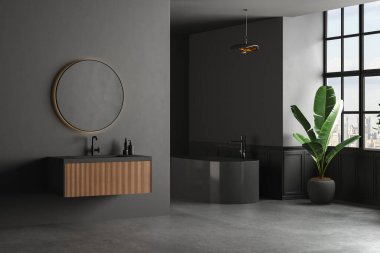 Beton zemini, siyah küveti ve siyah duvarda duran oval aynası olan karanlık bir banyo. Modern mobilyalı minimalist siyah banyo. 3B Hazırlama