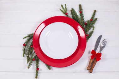 Köknar dalı ile Noel Masası Ayarları ve beyaz arkaplanda kırmızı süslemeler