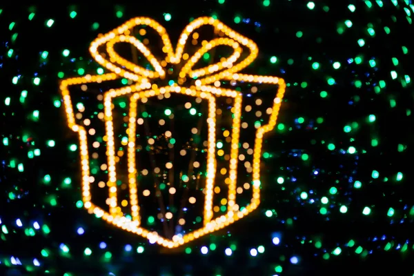 Bokeh gul jul presentask med en stor båge från färg ljus — Stockfoto