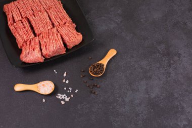 Taze kıymalı biftek, arka tabakta tuzlu biberli domuz eti.