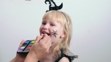 Annem Cadılar Bayramı partisi için güzel sarışın kıza makyaj yapıyor..