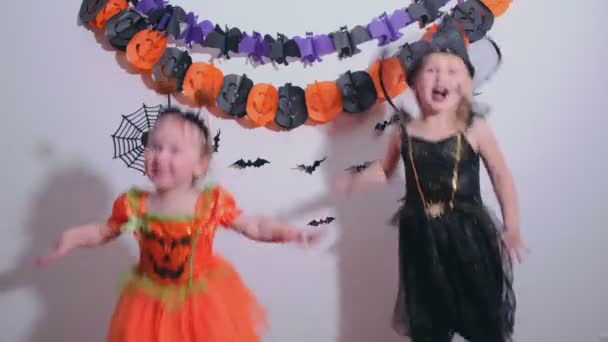 Duas irmãzinhas no traje de Halloween se divertindo dançando em casa — Vídeo de Stock