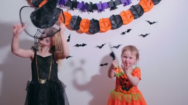 Halloween kinderen twee zusjes bereiden zich voor op Halloween trek thuis een kostuum aan. — Stockvideo