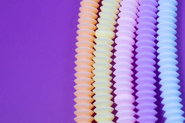 Tubos brillantes multicolores sobre fondo azul. Figura sensorial anti-estrés juguete de plástico. — Foto de Stock
