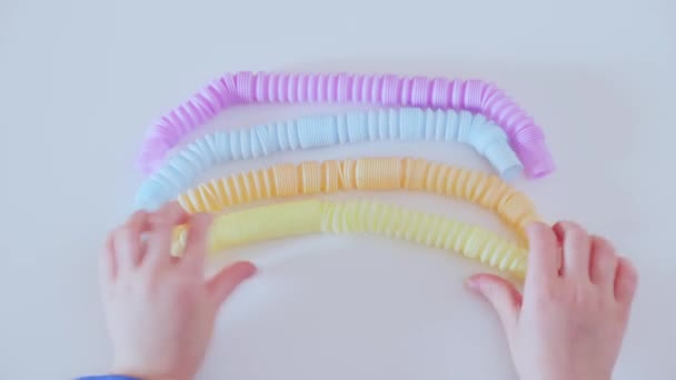 Main d'enfant jouant avec des jouets anti-stress Pop tube. — Video