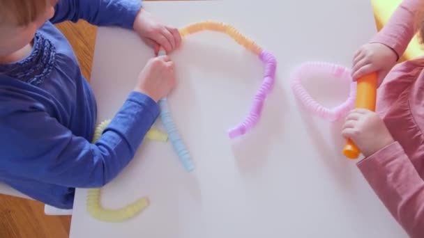 Le mani del bambino che giocano con i giocattoli del tubo pop anti-stress. — Video Stock