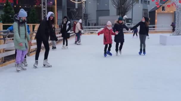 Kiev, Ucraina, ianuarie 2021: Oamenii merg pe patinoar în piața orașului în timpul Crăciunului și Anului Nou. — Videoclip de stoc
