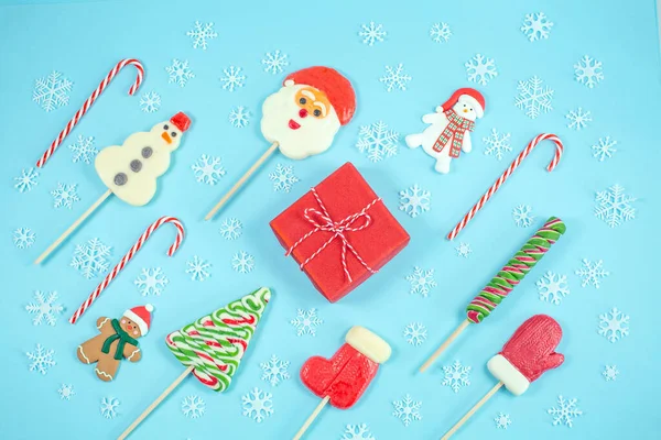 Caramelos de Navidad en forma de muñeco de nieve, árbol de navidad, santa claus, mitón y mini malvaviscos sobre fondo gris. — Foto de Stock