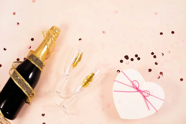 Champagne bottle with glasses and gift box in the shape of a heart — Stock Photo, Image