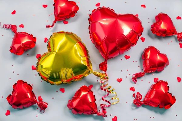 Rotgoldene Luftballons aus herzförmiger Folie auf grauem Hintergrund. . — Stockfoto