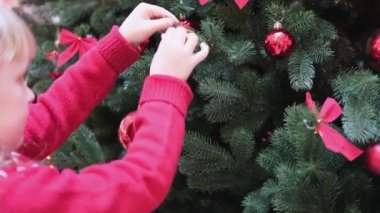 Çocuklar Noel ağacını kırmızı mücevherlerle süsledi..