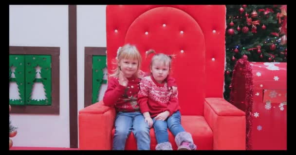 Kleine Mädchen im Weihnachtspulli winken mit der Handfläche und begrüßen mit Hallo-Geste jemanden — Stockvideo