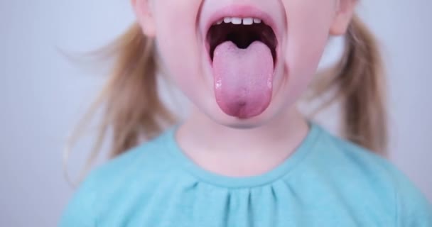 Little blond girl show tongue, throat. Kid training of muscles speech therapy. — Vídeo de Stock