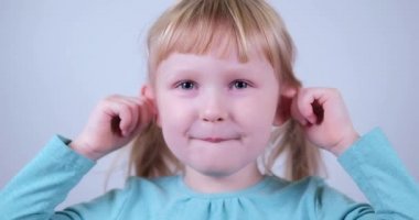 Şirin beyaz, sarışın kız komik maymun suratı yapıyor ve gülüyor..