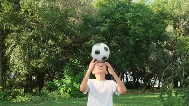Tiener jongen stuiterende bal met hoofd. Training in voetbal trucs. — Stockvideo