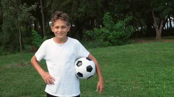Teenager Junge in Sportuniform mit einem Fußball macht Siegergeste ausdrucksstark — Stockvideo