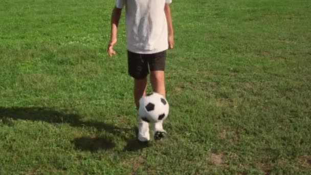 Vista de perto do menino praticando e treinando em truques de futebol. chuta a bola na perna. — Vídeo de Stock
