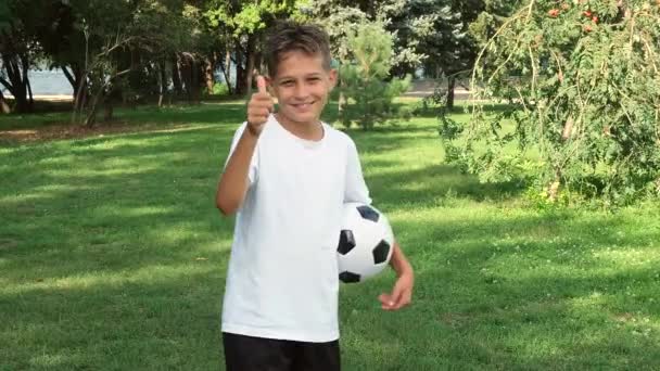 Teenager Junge in Sportuniform mit einem Fußballball macht Siegergeste ausdrucksstark und tanzt — Stockvideo