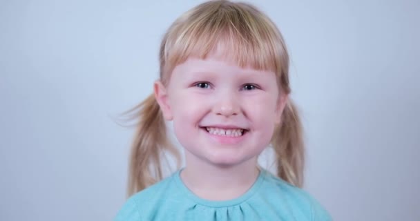 Portrait little blond Girl looking at camera and smile. Laughs Happily Child. — Stockvideo