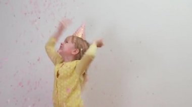Partide Mutlu Çocuk Şapkalı Kız Doğum günü partisinde konfetiyle atlıyor