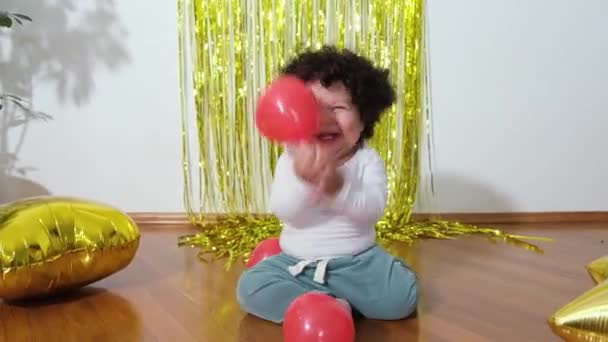 Happy mieszane wyścig maluch mały chłopiec siedzi na podłodze na tle urządzone pokoju jego urodziny. — Wideo stockowe