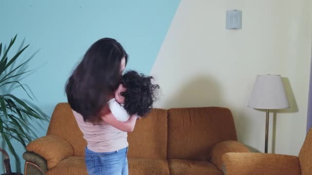 Feliz jovem adulto mãe segurando bonito Mixed-race criança pequeno filho segura e circulando na sala de estar. — Vídeo de Stock
