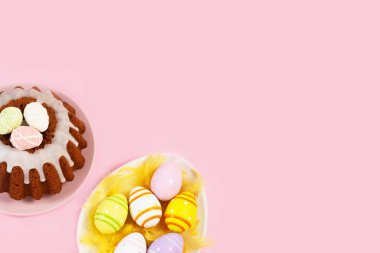 Yumurta şeklinde tabak, paskalya yumurtası ve pembe arka planda jöleli paskalya pastası..