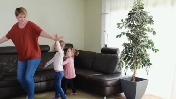 Moeder nanny heeft plezier met leuke kleine meisjes dansen in de woonkamer. Gelukkige familie. — Stockvideo