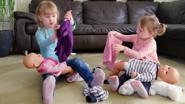 Zamknij się szczęśliwy uroczy mały przedszkolak dzieci dziewczyny grać cieszyć się grą z lalkami siedzi na dywanie w salonie, — Wideo stockowe