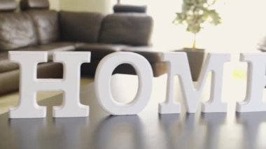 Wooden letters with the word home. Camera moves from the beginning of the word to the end.