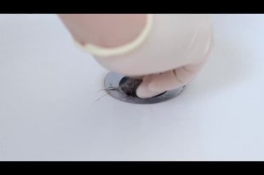 Erkek el banyodaki kanalizasyondan kadın saçı topuzu çekiyor..