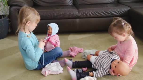 Close up happy adorable little preschool kids girls plays enjoy game with dolls sitting on a rug in the living room, — ストック動画