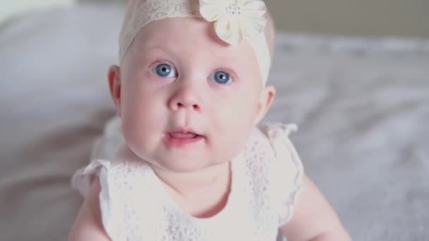 Carina Bambina Trova Sul Suo Stomaco Sul Letto Guardando Fotocamera — Video Stock