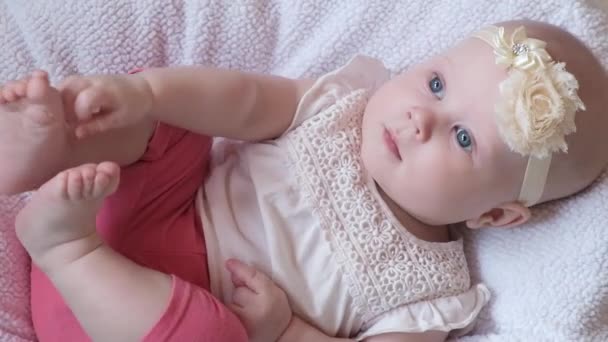 閉じます青い目の美しい小さな女の子は ベッドの上にあり カメラで笑顔 人生の最初の年における子供の発達 子供の保護 養子縁組 ベビーフードの概念 — ストック動画