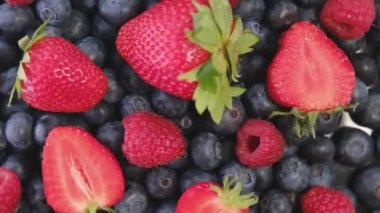 Blueberry, Strawberry and Raspberry, rotating backdrop. close-up. Blueberry and Raspberry with green leaf on rotating backdrop. close-up. Berries. Various colorful berries rotation background.Bio