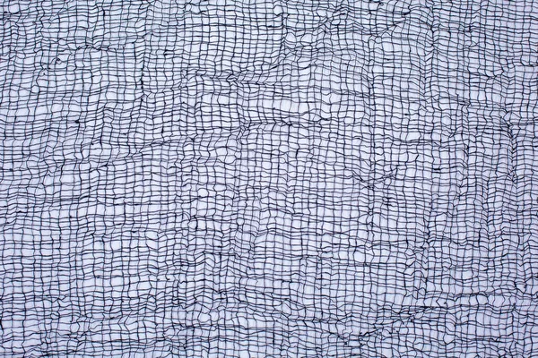 Black textile mesh on white background. Fabric, cobweb, background texture