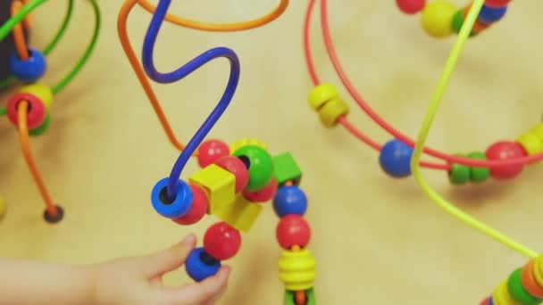 子供の手は木製のワイヤー迷路教育用ゲームおもちゃ幼児ブロックを再生します 手の論理と細かい運動能力の開発のためのゲーム 接近中だ 選択的焦点 — ストック動画